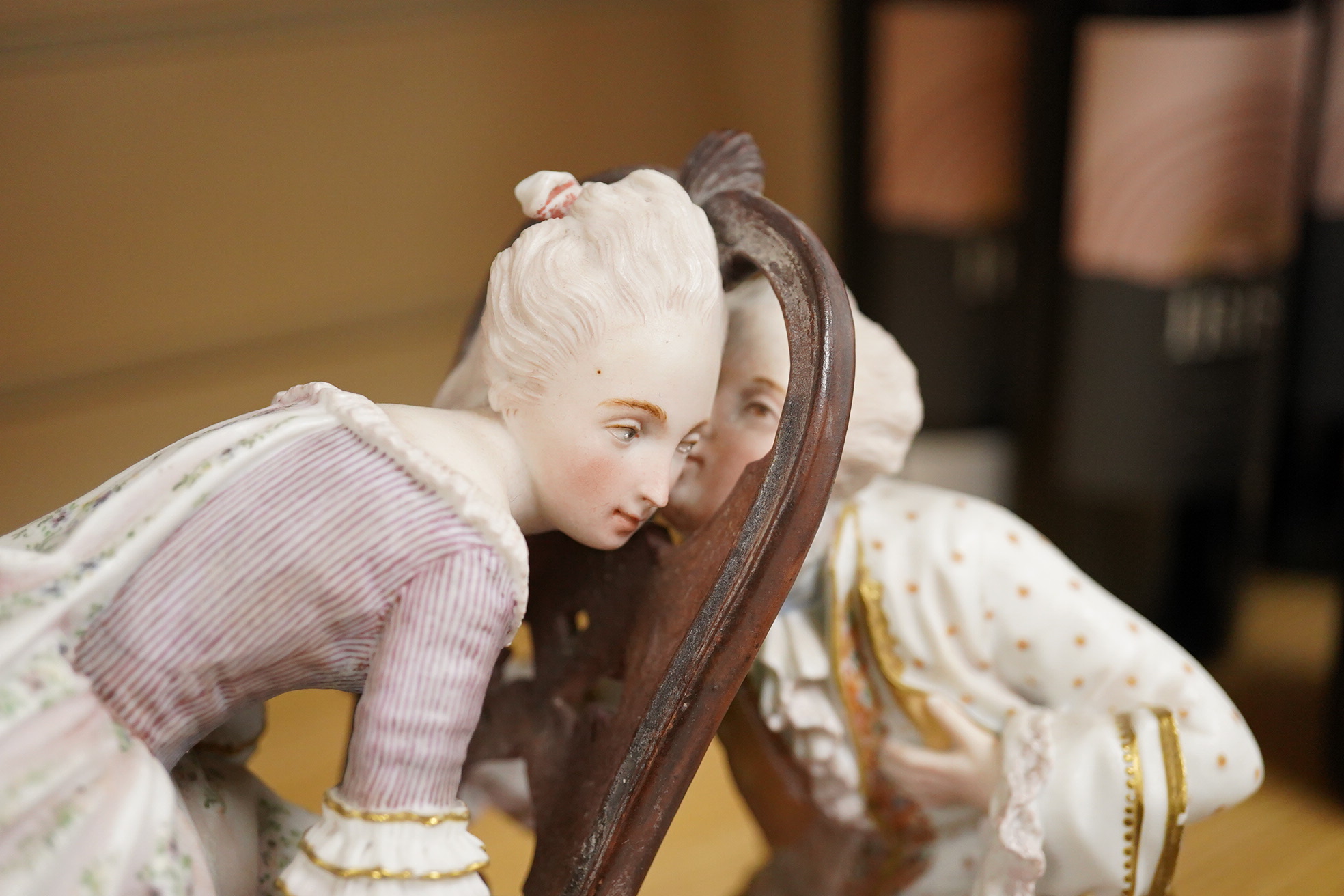A 19th century biscuit porcelain study of a courting couple under glass dome, raised on gilt base, 28cm high